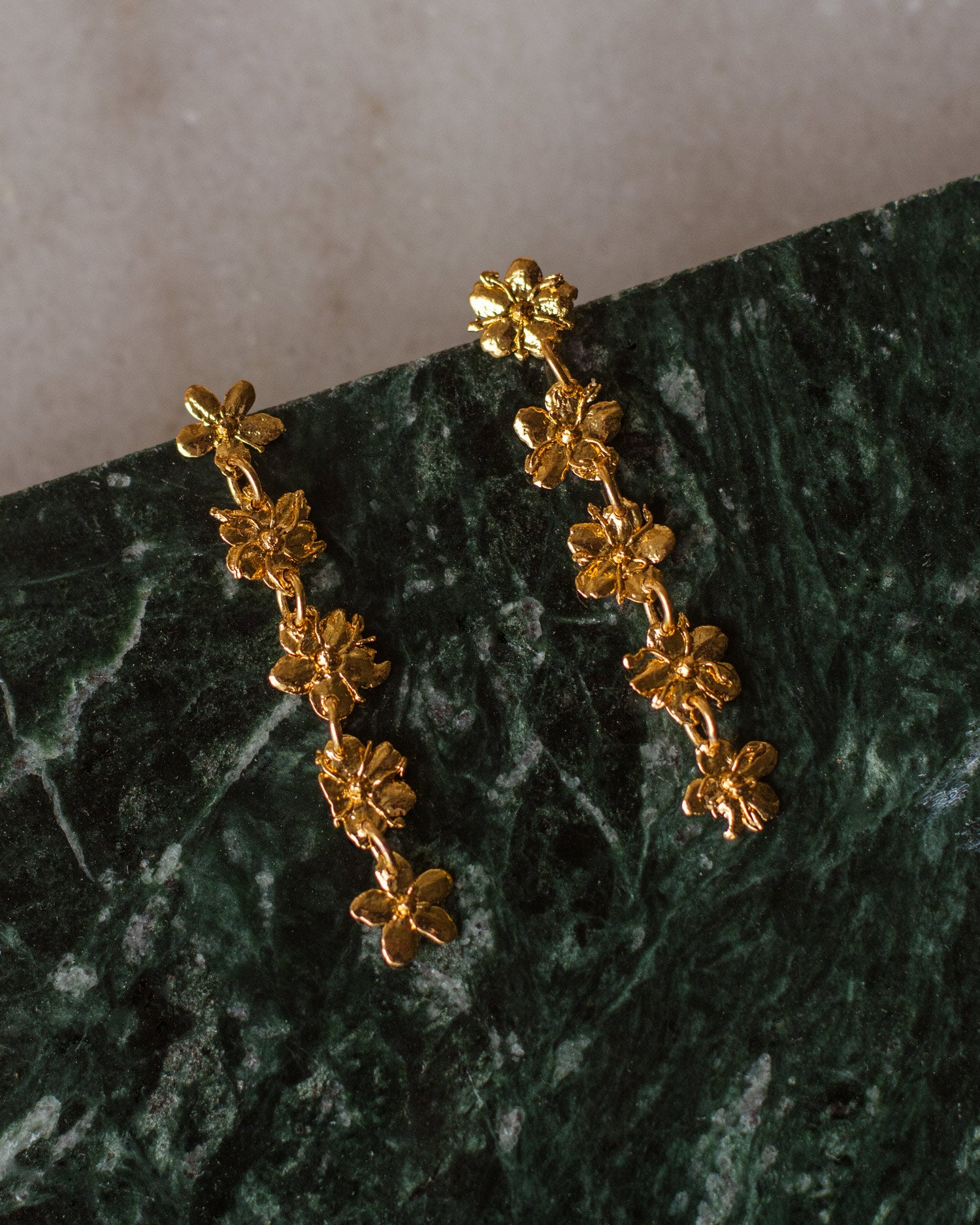 Aretes Cinco Saucos en bronce bañado en oro de 24k, mostrando la elegancia y la forma única de las flores de sauco naturales