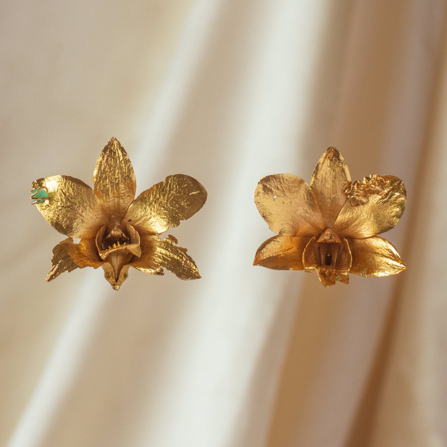 Aretes Orquidea Dendrobium natural inmortalizado en bronce con enchape de oro con detalle de esmeralda colombiana y flores de sauco