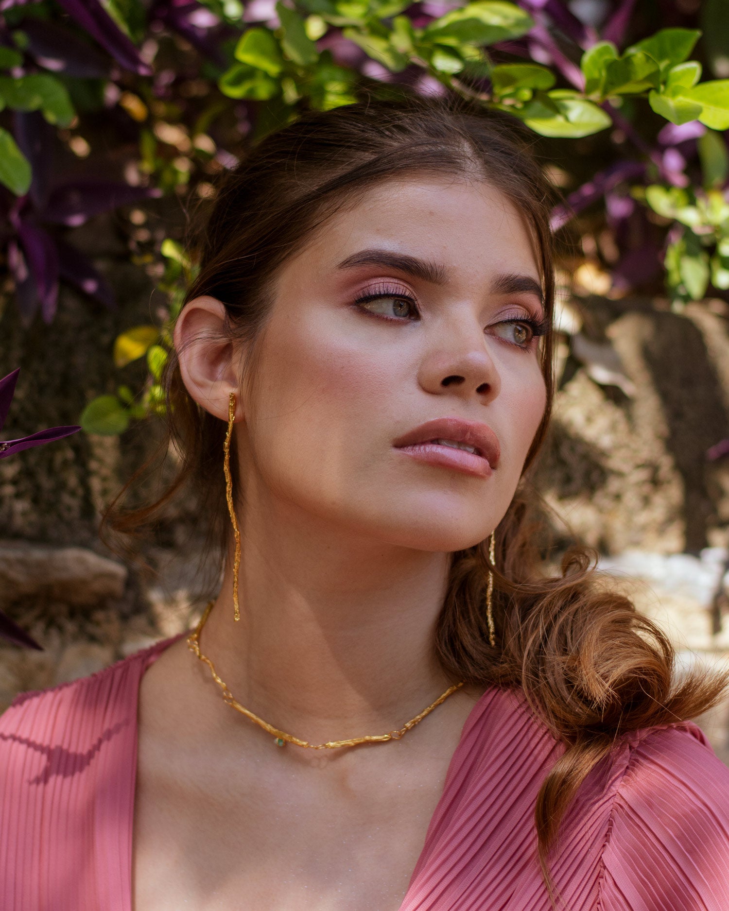 Collar Choker Ramita Palma Coco Esmeralda en bronce bañado en oro de 24k, destacando la textura natural de la ramita y el brillo verde de las esmeraldas