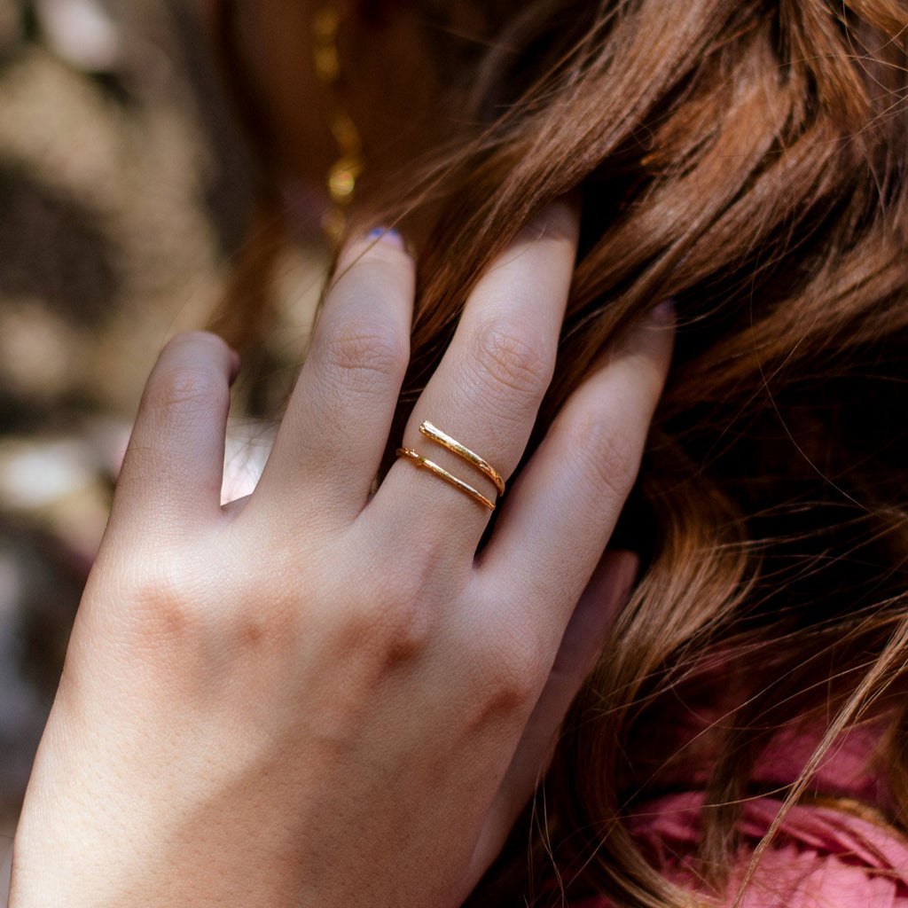 Anillo Ramita en bronce bañado en oro de 24k, destacando la textura y forma única de la ramita natural.