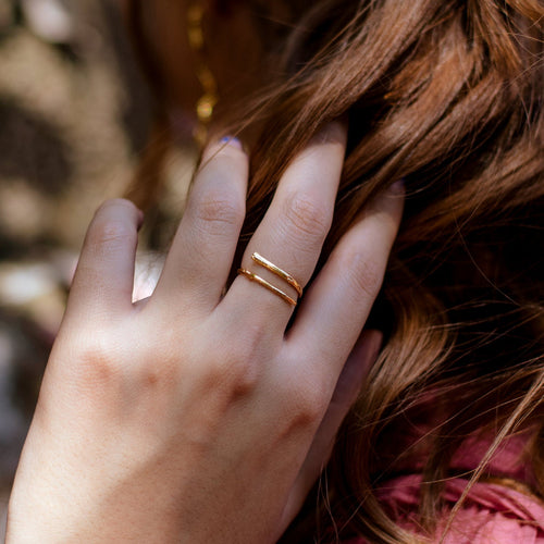 Anillo Ramita en bronce bañado en oro de 24k, destacando la textura y forma única de la ramita natural.