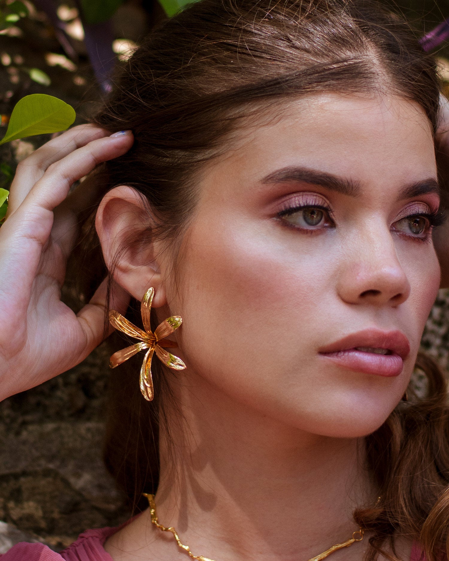 Aretes Topo Lirio Agapanto en bronce bañado en oro de 24k, destacando la belleza y singularidad de las flores naturales.